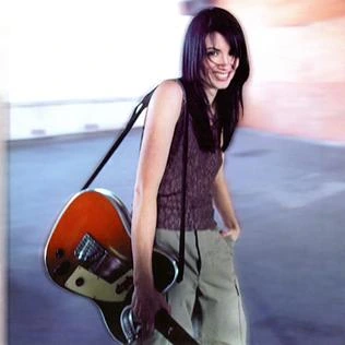 Meredith Brooks holding a guitar in a promotional photo from Blurring the Edges.