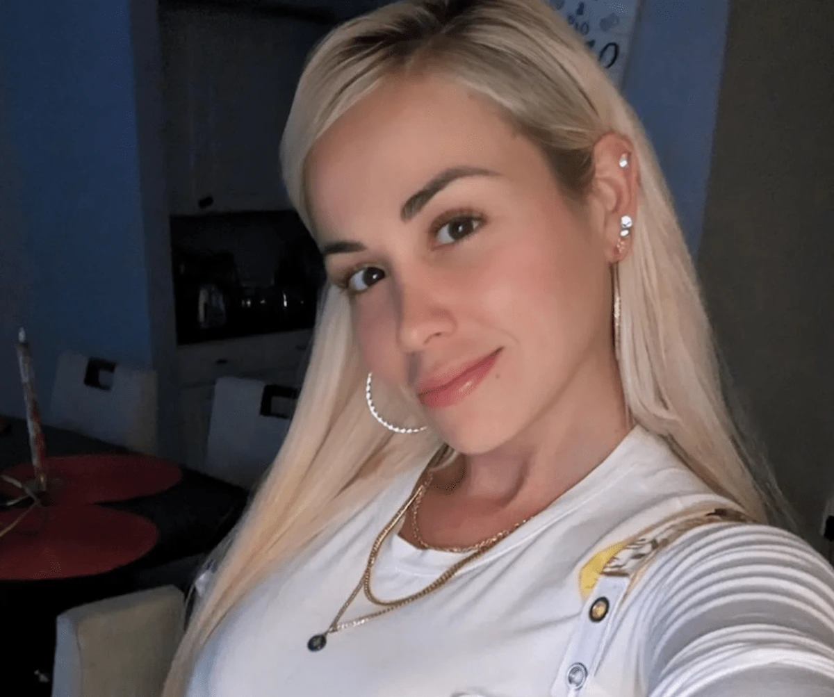 Paola Mayfield posing for a selfie in a white top