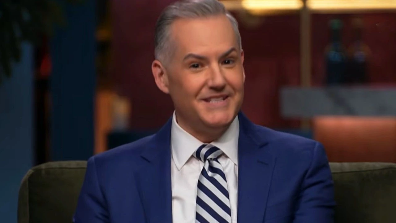 Tony Bryson in a blue suit during a television interview segment